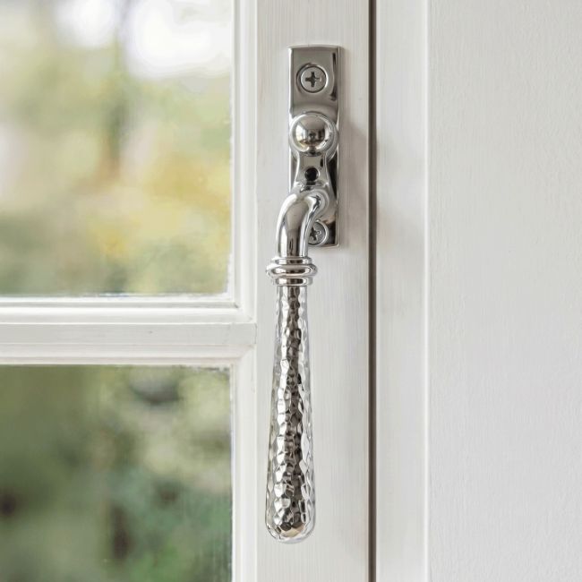 The Right Handed Bright Chrome Hammered Espag Window Handle Mounted on a Classic White Wooden Window Frame - Digital Illustration 