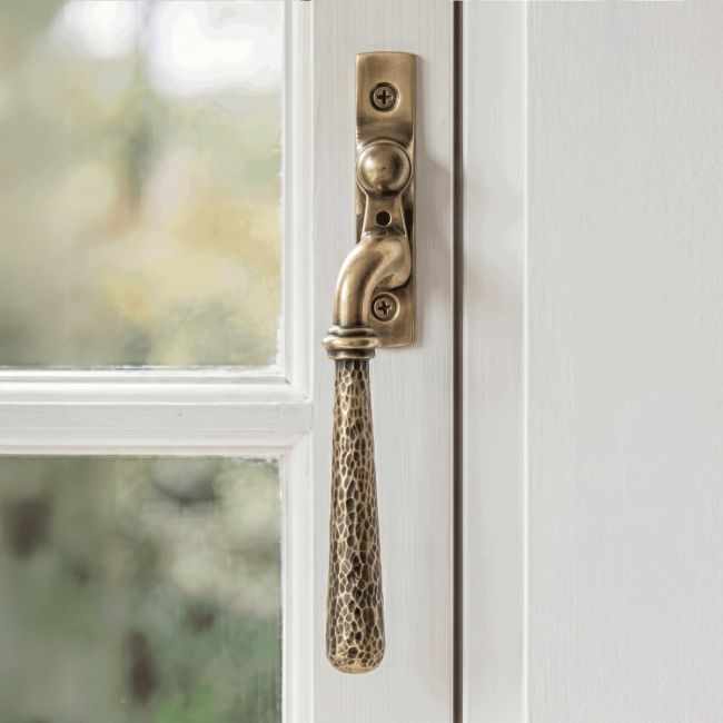 The Left Handed Polished Bronze Hammered Espag Window Handle on a Hand painted White Window Frame - Digital Illustration 
