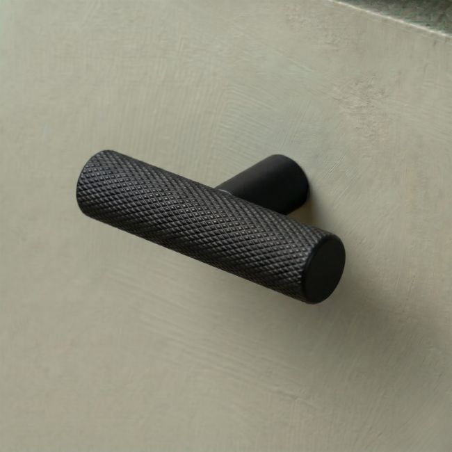The Matt Black "Astor" Knurled Industrial T-Bar Cabinet Fitting shown on a White Background at an Angle The Matt Black "Astor" Knurled Industrial T-Bar Cabinet Fitting shown on a White Background at an Angle
