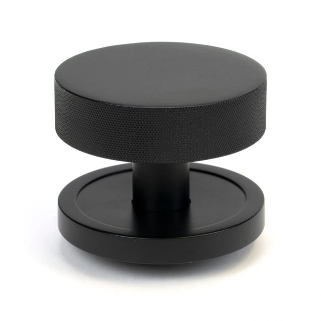 The Matt Black Knurled Centre Door Knob on a Plain Rose Shown Upright on a White Background The Matt Black Knurled Centre Door Knob on a Plain Rose Shown Upright on a White Background