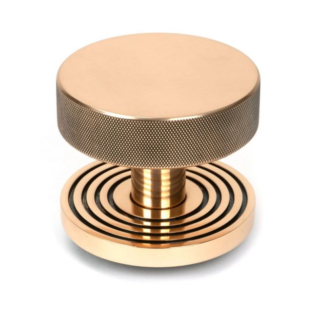 The Polished Bronze Knurled Centre Door Knob on a Beehive Rose Shown Upright on a White Background The Polished Bronze Knurled Centre Door Knob on a Beehive Rose Shown Upright on a White Background