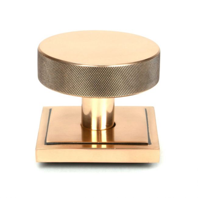 The Polished Bronze Knurled Centre Door Knob on a Square Rose Shown Upright on a White Background The Polished Bronze Knurled Centre Door Knob on a Square Rose Shown Upright on a White Background