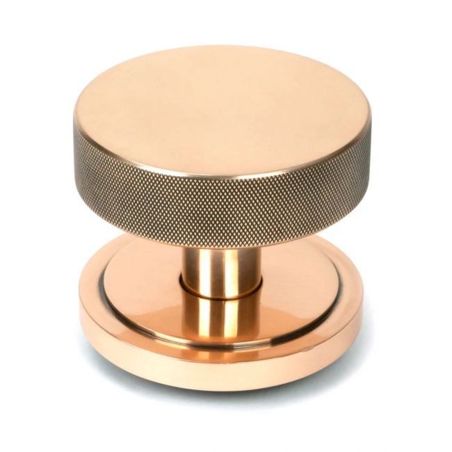 The Polished Bronze Knurled Centre Door Knob on an Art Deco Rose Shown Upright on a White Background The Polished Bronze Knurled Centre Door Knob on an Art Deco Rose Shown Upright on a White Background