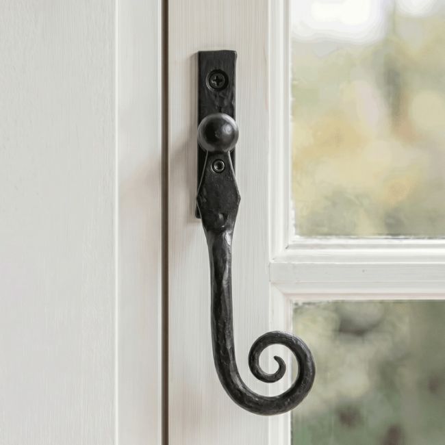 The Right Handed 16mm Beeswax Monkeytail Espagnolette Window Handle Fitted on a Traditional Window Frame in a Country Home - Digital Illustration
