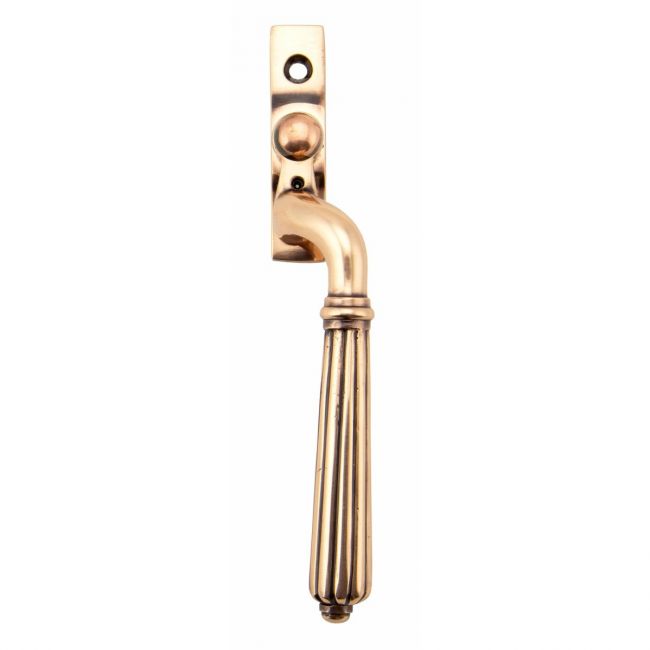 The Right Handed Polished Bronze Reeded Georgian Espagnolette Window Handle on a White Background The Right Handed Polished Bronze Reeded Georgian Espagnolette Window Handle on a White Background