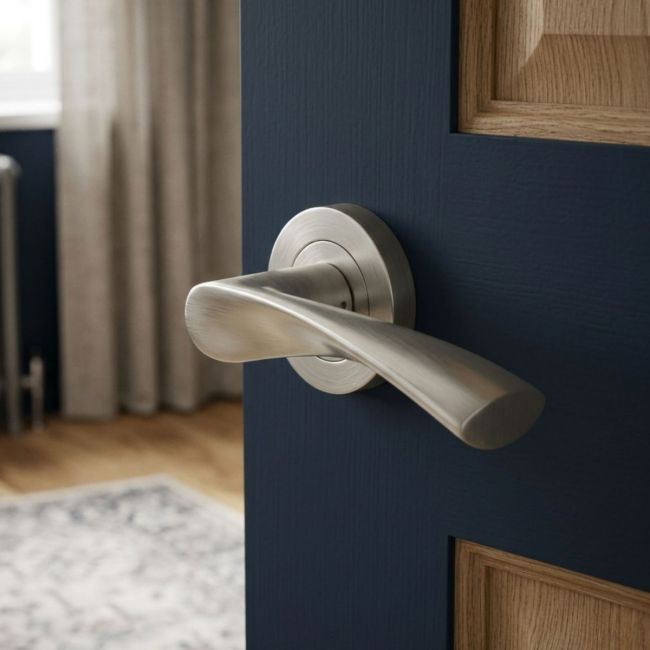 The Satin Nickel Modern Wave Lever Pair on a Round Rose Displayed on a White Background