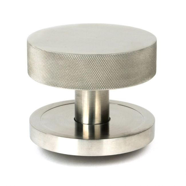 The Satin Stainless Steel Knurled Centre Door Knob on a Plain Rose Shown Upright on a White Background The Satin Stainless Steel Knurled Centre Door Knob on a Plain Rose Shown Upright on a White Background