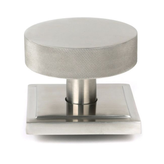 The Satin Stainless Steel Knurled Centre Door Knob on a Square Rose Shown Upright on a White Background The Satin Stainless Steel Knurled Centre Door Knob on a Square Rose Shown Upright on a White Background