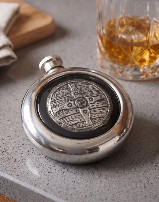 The Saxon Shield Whiskey Flask on a Grey Countertop next to a Tumbler of Whiskey - Digital Illustration The Saxon Shield Whiskey Flask on a Grey Countertop next to a Tumbler of Whiskey - Digital Illustration