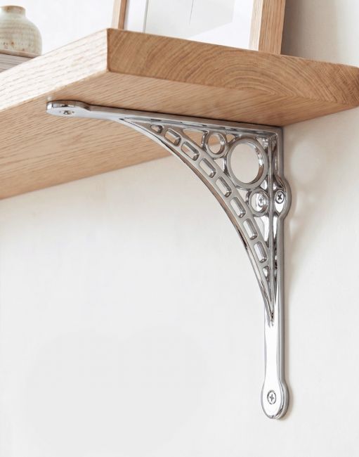 The Small 20cm x 22cm Bright Chrome "Iron Bridge" Shelf Bracket Mounted on a Plain white Interior Living Room Wall - Digital Illustration