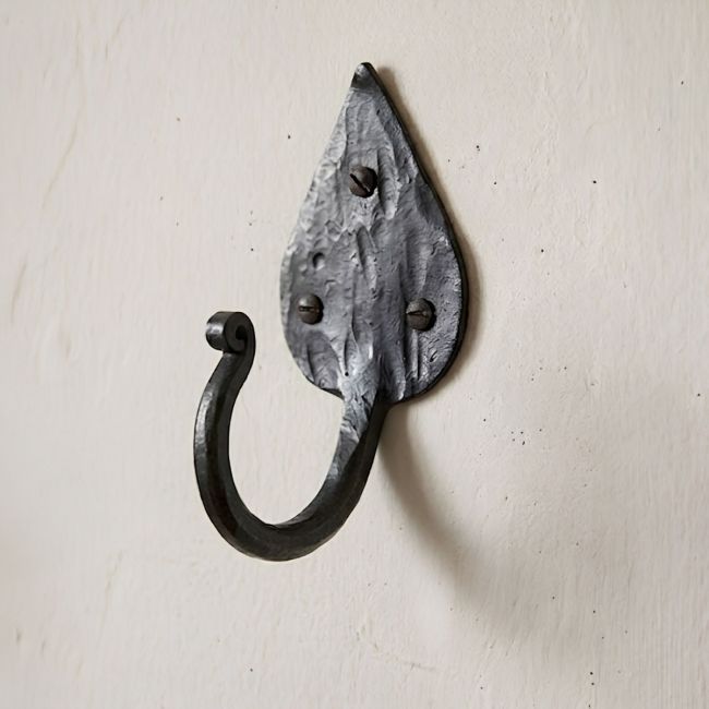 The Steel Leaf Shaped Hook mounted on a Textured Cream Wall - Digital Illustration 