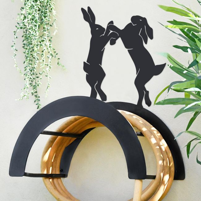 Wall Mounted Boxing Hares Iron Hose Holder Mounted to a Grey Garden Wall Wall Mounted Boxing Hares Iron Hose Holder Mounted to a Grey Garden Wall