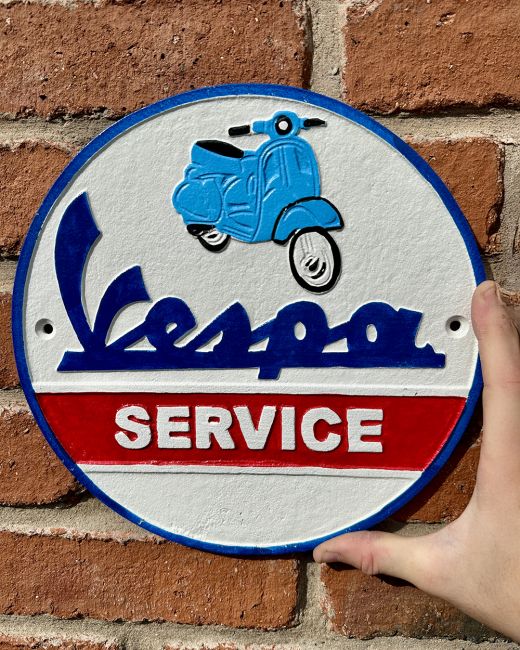 "Vespa" Automobilia Reproduction Sign in Situ Next to a Blue Wall "Vespa" Automobilia Reproduction Sign in Situ Next to a Blue Wall