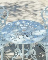 Close up of table top detail with parasol hole on white bistro set