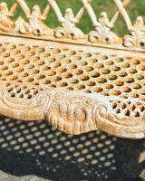 Close up of intricate seat detailing on rustic finish garden bench