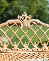 Close up of ornate lattice detailing on rustic finish champagne garden bench