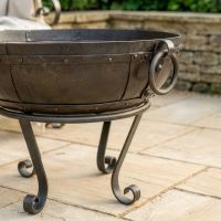 Digital Illustration of the 60cm Version of the Iron Kadai Bowl Fully Lit in Front of Rustic Garden Furniture Feet Close Up Digital Illustration of the 60cm Version of the Iron Kadai Bowl Fully Lit in Front of Rustic Garden Furniture Feet Close Up