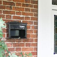 "Horncastle Abbey" Black Wall Mounted Post Box Next to a Front Door