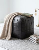 "The Cranborne" Black Leather Square Pouffe with a Blanket Draped over it in a Cosy Living Room - Digital Illustration