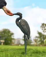 "Caspian" the Heron Cast Aluminium Garden Sculpture on a Garden Lawn with Hand in Shot for Scale