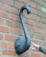 "Coral" Flamingo Wall Art in Cast aluminium - Verdigris on brick wall to scale with hand in shot "Coral" Flamingo Wall Art in Cast aluminium - Verdigris on brick wall to scale with hand in shot