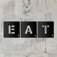 "EAT" Black Scrabble Square Letters in situ on a Rustic Wall "EAT" Black Scrabble Square Letters in situ on a Rustic Wall