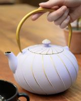 "Fuji" Cast Iron Japanese Style Teapot with a Purple and Gold Finish with Hand in Shot for Scale "Fuji" Cast Iron Japanese Style Teapot with a Purple and Gold Finish with Hand in Shot for Scale