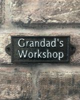 "Grandad"s Workshop" Traditional Cast Iron Wall Sign black and white mounted on a wall