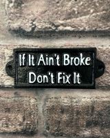 "If it ain"t Broke Don"t Fix It" Traditional Cast Iron Wall Sign mounted on a brick wall