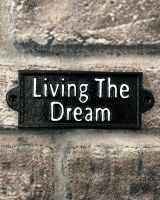 "Living the Dream" Traditional Cast Iron Wall Sign mounted on a brick wall