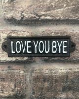 "Love You Bye" Traditional Cast Iron Wall Sign mounted on a brick wall