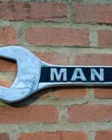 "Man Cave" Spanner Sign in Cast Aluminium Wall Art Mounted on a Brick Wall Close up of Left Side "Man Cave" Spanner Sign in Cast Aluminium Wall Art Mounted on a Brick Wall Close up of Left Side