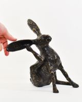 "Meadow Muse" Cast Brass Grooming Hare Sculpture with hand in shot for scale