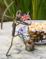 "Miner" Upcycled Metal Home Ornament holding pickaxe in front of cake