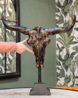 "Montana" Cast Aluminium Long Horn Skull Positioned on a Table Inside a Home with a Hand in Shot for Scale