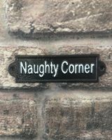 "Naughty Corner" Traditional Cast Iron Wall Sign mounted on a brick wall