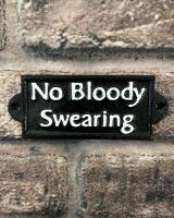 "No Bloody Swearing" Traditional Cast Iron Wall Sign mounted on a brick wall
