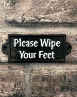 "Please Wipe your Feet" Traditional Cast Iron Wall Sign mounted on a wall