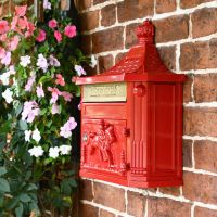 Close-up of the Red Wall Mounted Post Box Mounted on a Brick Wall