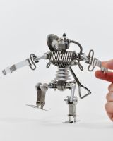 ‘Stainless Sentinel’ Upcycled Stainless Steel Robot walking forward with hand to reference scale