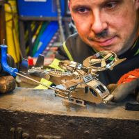 "Valkyrie" Military Helicopter Stainless Steel Sculpture close up with engineer building sculpture "Valkyrie" Military Helicopter Stainless Steel Sculpture close up with engineer building sculpture