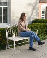 "Vienne" Two Seater Wrought Iron Garden Bench - Cream with lady sat on bench