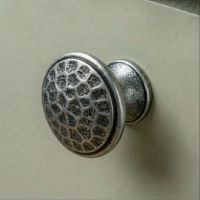 A 40mm Hammered Pewter Cabinet Knob Mounted on a Contemporary Sage Green Kitchen Cabinet - Digital Illustration