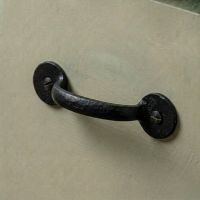 A Black Iron Round Plated Pull Handle Mounted on a Green Kitchen Cabinet - Digital Illustration 