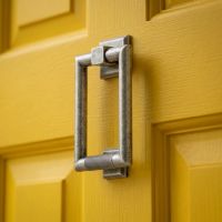 A Bright Yellow Front Door with a Modern Knurled Rectangular Door Knocker in a Pewter Finish Fitted on to it - Digital Illustration