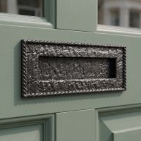 A Cast Iron Black Letter Plate With Scrolled Edge on a Sage Green Door with Glass Panels - Digital Illustration