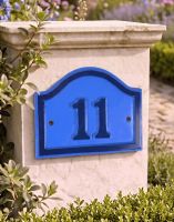 A Number 11 Blue and Dark Blue Painted Arched House Number Sign Mounted on a Entrance Driveway - Digital Illustration
