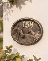 A Number 158 "Sanshire Stallion" Horse Number Sign in a Bronze Finish Mounted on a Sunny White Garden Wall - Digital Illustration A Number 158 "Sanshire Stallion" Horse Number Sign in a Bronze Finish Mounted on a Sunny White Garden Wall - Digital Illustration