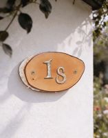 A Number 18 Natural Hard Wood Rustic House Number Sign Mounted on a Sunny Cream Coloured Wall - Digital Illustration