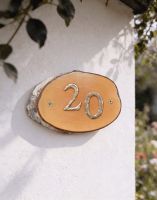 A Number 20 Natural Hard Wood Rustic House Number Sign Mounted on a Sunny Cottage Wall - Digital Illustration
